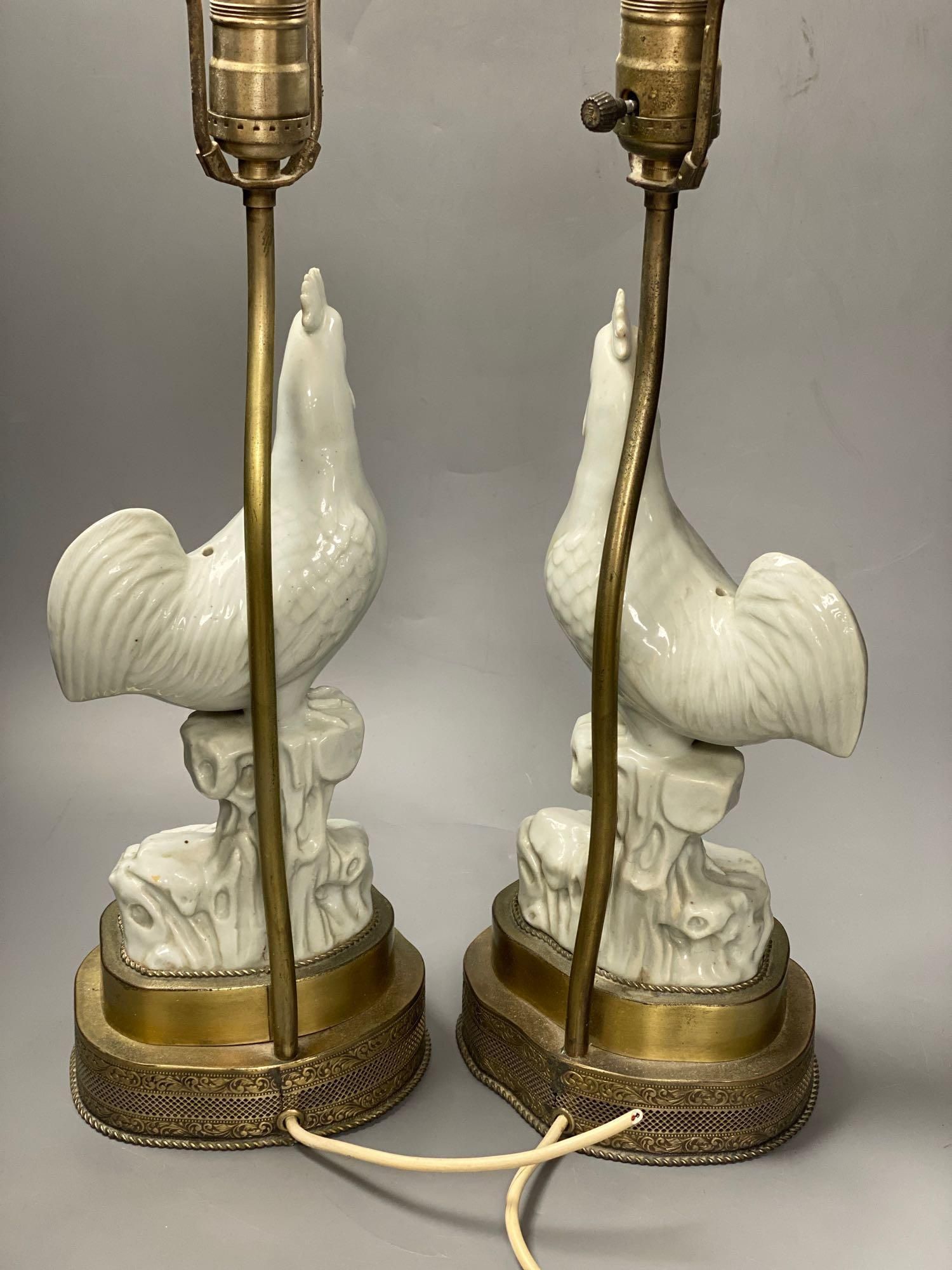 A pair of blanc de chine cockerel lamps, total height 64cm